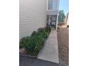 Townhome entrance featuring manicured shrubbery, a walkway to the door, and a secure storm door for added peace of mind at 12592 E Cornell Cir, Aurora, CO 80014