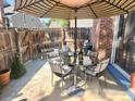 Private brick patio with dining area, a shade umbrella, and a view of the lush surroundings, great for entertaining at 12592 E Cornell Cir, Aurora, CO 80014