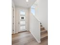 Modern entryway with white door and hardwood floors at 5215 Queen Ct, Arvada, CO 80002