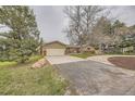 Single-story home featuring an attached garage, a driveway, and mature landscaping at 8102 S Carr Ct, Littleton, CO 80128