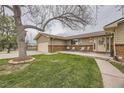 Inviting front yard with a well-maintained lawn and a cozy porch area with seating at 8102 S Carr Ct, Littleton, CO 80128