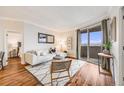Bright living room featuring a white sofa, modern rug, and sliding glass doors to a balcony at 601 W 11Th Ave # 1101, Denver, CO 80204