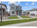 Charming two-story home with a red door, landscaped yard, and concrete walkway, and a fire hydrant nearby at 21202 E 63Rd Dr, Aurora, CO 80019