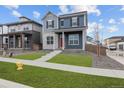 Stylish two-story home with vibrant landscaping, a bright red door, and modern architectural details at 21202 E 63Rd Dr, Aurora, CO 80019