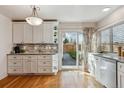 Bright kitchen with white cabinets, stainless steel appliances, and access to outdoor space at 7641 S Rosemary Cir, Centennial, CO 80112