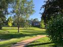 A view from the yard overlooking a grassy area with mature trees, and walking paths at 7641 S Rosemary Cir, Centennial, CO 80112