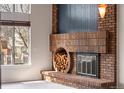 Unique brick fireplace features a wood storage nook and modern design at 7647 S Crocker Ct, Littleton, CO 80120