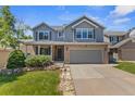 Beautiful two-story home with a well-kept lawn, a two-car garage and decorative stone elements at 14185 W Warren Cir, Lakewood, CO 80228