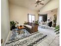 Inviting living room with a vaulted ceiling, open to the dining area and filled with an assortment of plants at 9680 Brentwood Way # 202, Broomfield, CO 80021