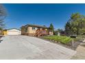 Quaint brick home with large driveway and front yard at 3871 Moore St, Wheat Ridge, CO 80033