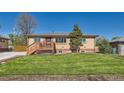 Charming single-story brick home with a cozy front porch and well-manicured lawn at 3871 Moore St, Wheat Ridge, CO 80033