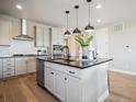 Modern kitchen with stainless appliances, white cabinets, and an island with seating at 18940 E 96Th Pl, Commerce City, CO 80022