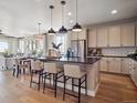 Bright, open kitchen featuring a center island, stainless steel appliances, and modern pendant lighting at 18940 E 96Th Pl, Commerce City, CO 80022