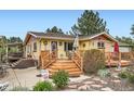 Inviting front entrance with a wooden porch, landscaped garden, and charming decor at 15325 W 32Nd Ave, Golden, CO 80401