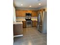 Kitchen with stainless steel appliances and oak cabinets at 21459 Randolph Pl, Denver, CO 80249