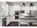 Modern kitchen with white cabinets, stainless steel appliances, granite counters, and island seating at 181 S Monaco Pkwy, Denver, CO 80224