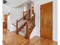 View of the foyer with hardwood floors, a wooden staircase, and a convenient coat closet at 2990 S Jay St, Denver, CO 80227