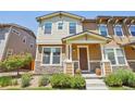 Inviting two-story home with stone accents, a covered porch, and manicured front yard landscaping at 1557 S Dallas Cir, Denver, CO 80247