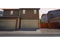 Spacious two-car garage with individual doors and paved driveway in a townhome community at 1557 S Dallas Cir, Denver, CO 80247