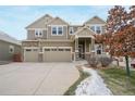 Spacious home with a large driveway, three-car garage, stone accents, and professionally landscaped yard at 10003 Atlanta St, Parker, CO 80134