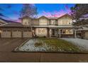 Attractive two-story home featuring a spacious three-car garage and well-maintained lawn with snow-covered areas at 11418 W Roxbury Ave, Littleton, CO 80127