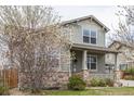 Charming two-story home with a cozy front porch, stone accents and a well-maintained lawn at 11801 E 118Th Ave, Commerce City, CO 80640