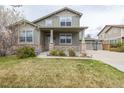 Charming two-story home with a cozy front porch, stone accents and a well-maintained lawn at 11801 E 118Th Ave, Commerce City, CO 80640