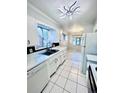 Bright kitchen with white cabinets and a view into the dining room at 3231 S Galapago St, Englewood, CO 80110