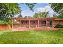 Large back deck with pergola, seating, and view of the green lawn and brick exterior at 3071 S Jasmine St, Denver, CO 80222