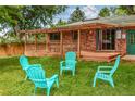 Backyard featuring a grassy lawn, wooden fence, and four Adirondack chairs at 3071 S Jasmine St, Denver, CO 80222