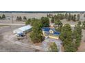 Aerial view showing a yellow home with solar panels, a matching shed, and a long dirt driveway at 37677 Sable Ridge Rd, Elizabeth, CO 80107