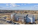 A beautiful birds-eye view of the blue condominium building including the parking lot and mountain range at 3121 S Tamarac Dr # 102, Denver, CO 80231