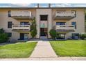 Well-maintained condo building featuring a central entrance and lush green lawn at 420 Zang St # 3-208, Lakewood, CO 80228