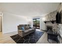 Inviting living room with a stone fireplace, modern decor, and sliding glass door at 420 Zang St # 3-208, Lakewood, CO 80228