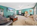 Cozy living room with plush carpet, a fireplace, comfortable seating, and a ceiling fan at 7745 Grant St, Denver, CO 80229