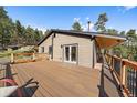 Large wooden deck with railing and comfortable seating, ideal for outdoor relaxation at 34 Normandy Rd, Evergreen, CO 80439