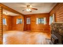 Living room with wood paneled walls, wood burning stove, and a ceiling fan at 184 Signal Rock Rd, Golden, CO 80403