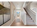 Inviting foyer with wood floors leads to a bright and airy living space, complete with staircase and decor at 1415 Orchard St, Brighton, CO 80601