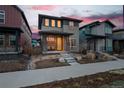 Contemporary home with a yellow door, landscaped front yard and front porch in a colorful neighborhood at 6052 N Malta St, Aurora, CO 80019