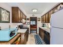 Efficient kitchen layout with dark wood cabinets and appliances, perfect for meal preparation at 6330 E Wesley Ave, Denver, CO 80222