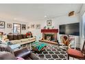Inviting living room with cozy seating, brick fireplace, and decorative accents for a comfortable ambiance at 6330 E Wesley Ave, Denver, CO 80222