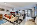 Bright living room featuring a brick fireplace, sliding glass doors, and hardwood-style floors at 6330 E Wesley Ave, Denver, CO 80222