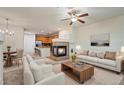 Inviting living room featuring a fireplace, ceiling fan, and open floorplan with natural light at 9907 Martin Luther King Blvd # 103, Denver, CO 80238