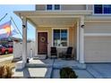 Inviting covered front porch with comfortable seating, perfect for relaxing outdoors at 21088 Randolph Pl, Denver, CO 80249