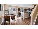 Bright kitchen with an island, dark cabinets, and a dining area with sliding glass doors at 21088 Randolph Pl, Denver, CO 80249