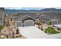 Charming gray home with a three car garage and beautifully xeriscaped front yard at 16840 New Autumn Dr, Monument, CO 80132