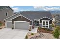 Charming gray home with a three car garage and beautifully xeriscaped front yard at 16840 New Autumn Dr, Monument, CO 80132