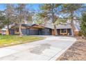 Charming single-story home featuring a painted brick exterior, well-maintained lawn, mature trees, and a long driveway at 417 S Pontiac Way, Denver, CO 80210