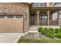 Charming home entrance with stone details, a covered porch, and a three-car garage at 2165 Summerlin Ln, Longmont, CO 80503