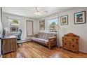 Bright bedroom with hardwood floors, a futon, and natural light from two windows at 5445 Reed Ct, Arvada, CO 80002